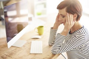 woman with headache at desk