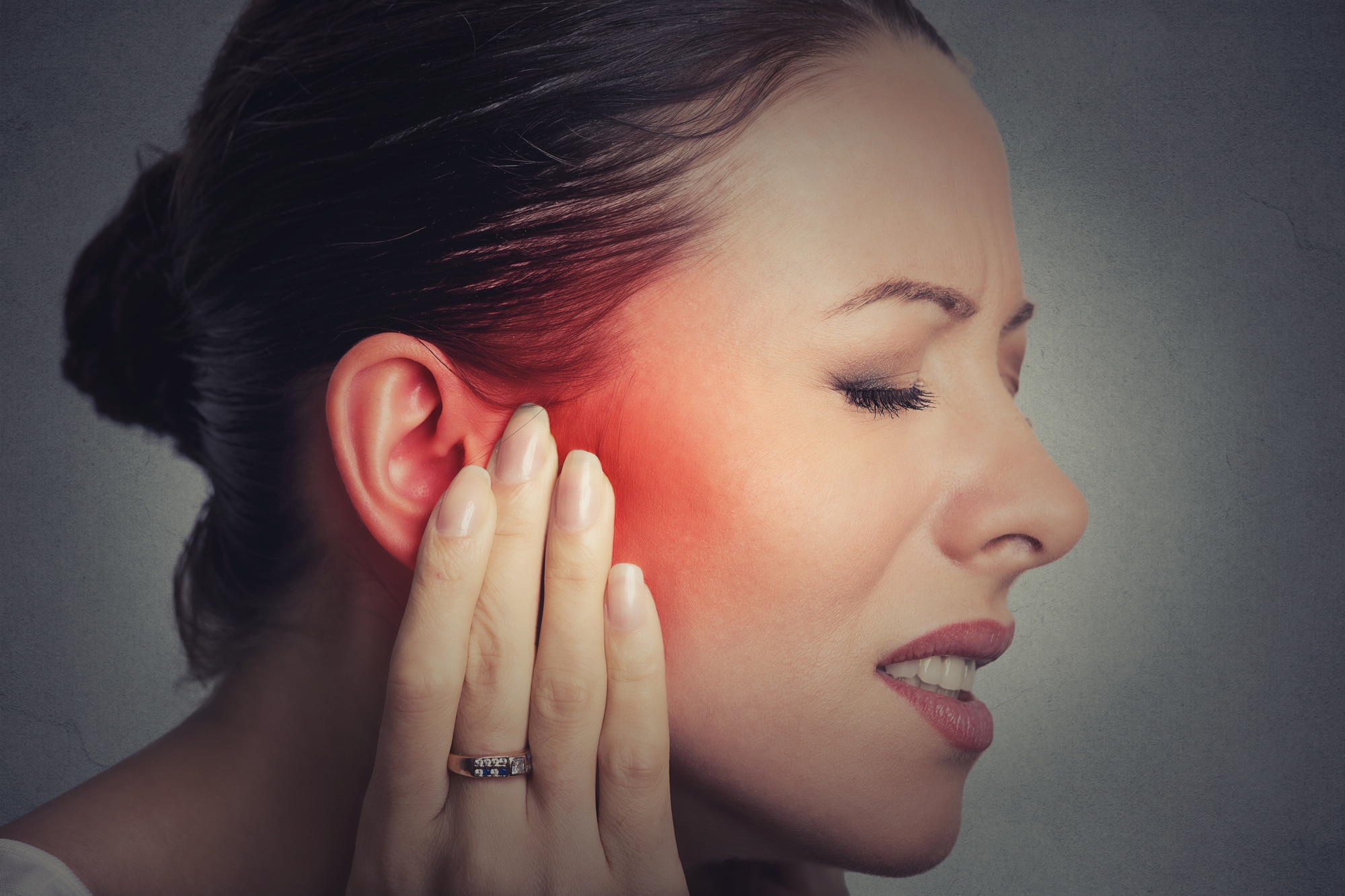 woman touching ear in pain